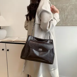 Large dark brown leather tote bag with silver chain strap and metal swivel lock