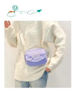Détail d'un sac bandoulière en velours côtelé violet clair avec broderie ours mignon