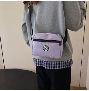 Detail showing purple nylon crossbody bag with Sport logo and adjustable strap