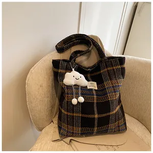 Dettaglio di una borsa tote scozzese vintage con un morbido ciondolo a forma di nuvola