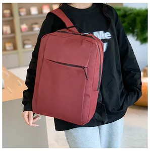 Burgundy business backpack with front zipper pocket and padded straps shown in use