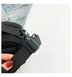 Détail de la bandoulière réglable en nylon noir sur un sac à bandoulière en velours
