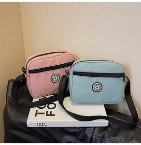 Detail of pink and blue nylon crossbody bags with sport logo and adjustable straps