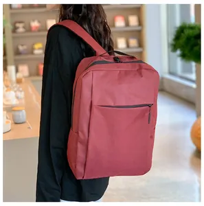 Burgundy business laptop backpack with front zipper pocket shown in library setting