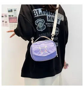 Détail d'un sac bandoulière en velours côtelé violet avec broderie animalière mignonne