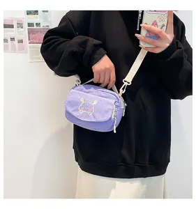 Détail du sac à bandoulière en velours côtelé violet avec broderie mignonne et sangle