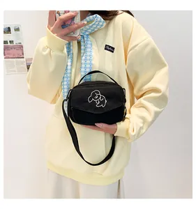 Detail van schattig hond borduursel op kleine zwarte corduroy crossbody tas dames