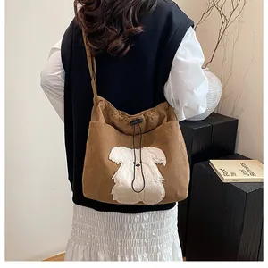Detailed view of brown corduroy tote with plush puppy applique and drawstring closure