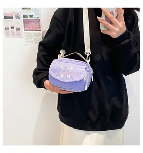 Détail d'un petit sac carré en velours côtelé violet avec broderie de dessin animé