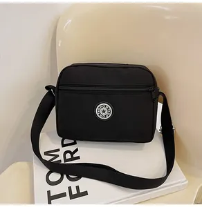 Close-up of black nylon crossbody bag with Sport logo and adjustable fabric strap