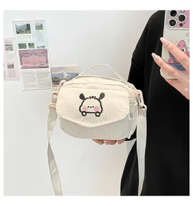 Détail du mini sac à bandoulière en velours côtelé beige avec broderie chiot mignon