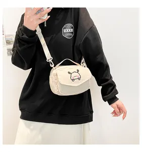 Vue détaillée du petit sac bandoulière en velours côtelé beige avec broderie chiot