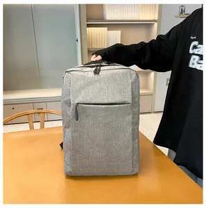 Close-up of a grey laptop backpack with dual zippers and a sturdy top handle on a table