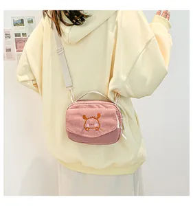 Détail d'un sac bandoulière en velours côtelé rose avec broderie animale mignonne