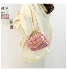 Détail d'un petit sac bandoulière en velours côtelé rose avec broderie animale mignonne