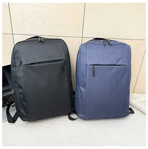 Business backpacks in black and navy blue shown with laptop and newspaper on textured rug