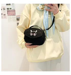 Détail du petit sac bandoulière en velours côtelé noir avec broderie lapin blanc