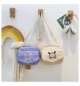 Détail des sacs à bandoulière en velours côtelé lavande et beige avec broderie mignonne
