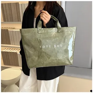 Dettaglio della borsa tote in PVC impermeabile verde oliva con scritta TOTE BAG in bianco
