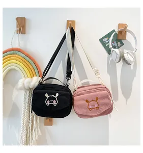 Détails du sac bandoulière en velours côtelé avec broderie animale et bandoulière réglable