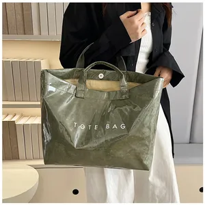 Dettaglio della borsa lucida verde oliva con chiusura magnetica e capienza interna
