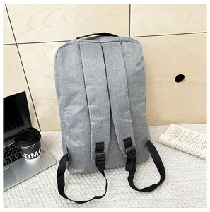 Rear view of grey business laptop backpack with adjustable straps on a white knitted rug