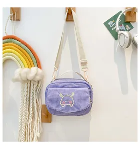 Détail de la sacoche en velours côtelé violet avec broderie animale et sangle réglable