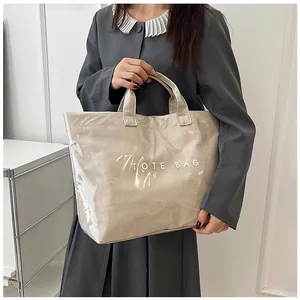Dettaglio di una borsa tote in PVC trasparente con interno in carta DuPont e logo
