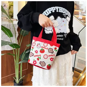 Detail der rot-cremefarbenen Canvas-Tasche mit süßen Cartoondrucken und stabilen Griffen