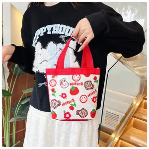 Detailansicht der niedlichen Canvas-Tasche mit roten Griffen und Comic-Mustern
