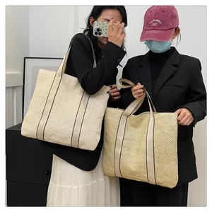 Detail von gewebten Stroh-Tote-Taschen in Beige und Hellbraun mit robusten Canvas-Riemen