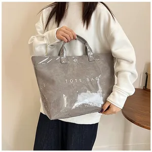 Dettaglio della borsa tote grigia in PVC impermeabile con scritta TOTE BAG bianca