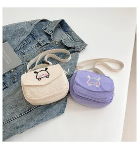 Détail de sacs bandoulière en velours côtelé avec broderie chien et bandoulières réglables