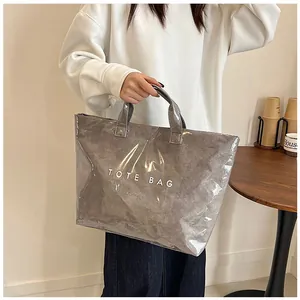 Dettaglio borsa tote grigia impermeabile in PVC con scritta TOTE BAG per pendolari