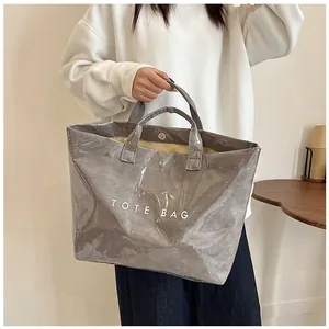 Dettaglio macro della borsa tote grigia lucida con chiusura magnetica in metallo