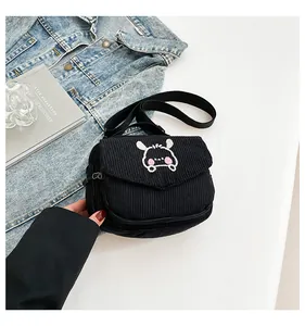 Détail du petit sac bandoulière en velours côtelé noir avec broderie animale mignonne