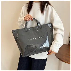 Dettaglio della borsa tote in PVC grigio lucido con scritta TOTE BAG bianca e rifiniture