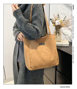 Vue détaillée du sac cabas en velours côtelé marron avec l'écusson tissé FASHION INSTINCT