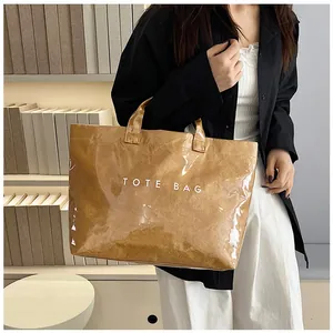 Grande borsa tote marrone in PVC lucido con scritta TOTE BAG e texture stropicciata