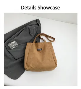 Détail du sac cabas en daim marron avec étiquette tendance et bandoulières souples