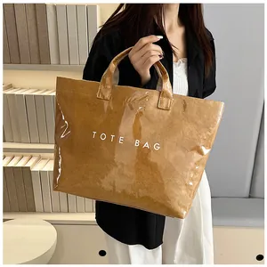 Dettaglio di una borsa tote marrone impermeabile in PVC con texture effetto carta