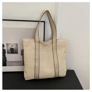 Detail der beigen Flechtstruktur und braun eingefassten Riemen dieser geräumigen Tote
