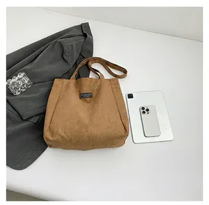 Vue détaillée du sac cabas en daim marron avec l'étiquette tissée Fashion Instinct