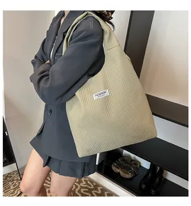 Close-up of khaki corduroy tote bag showing striped texture and Fashion Instinct label