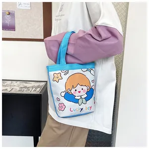 Detailansicht der kleinen Canvas-Eimertasche mit süßem Lucky Boy Motiv und blauen Griffen