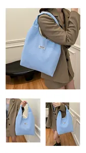 Detail view of light blue corduroy tote bag featuring a white Fashion Instinct patch