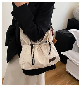 Détail d'un sac bandoulière en nylon avec cordon de serrage et charm peluche