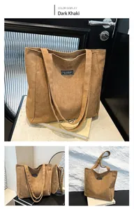 Détail du sac cabas en daim kaki foncé avec logo Fashion Instinct et longue bandoulière