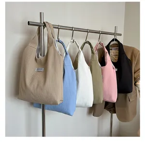 Macro detail of high-capacity corduroy tote bags in six colors with a fashion cloth label