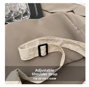 Détail de la bandoulière réglable en nylon blanc cassé avec boucle en plastique noir